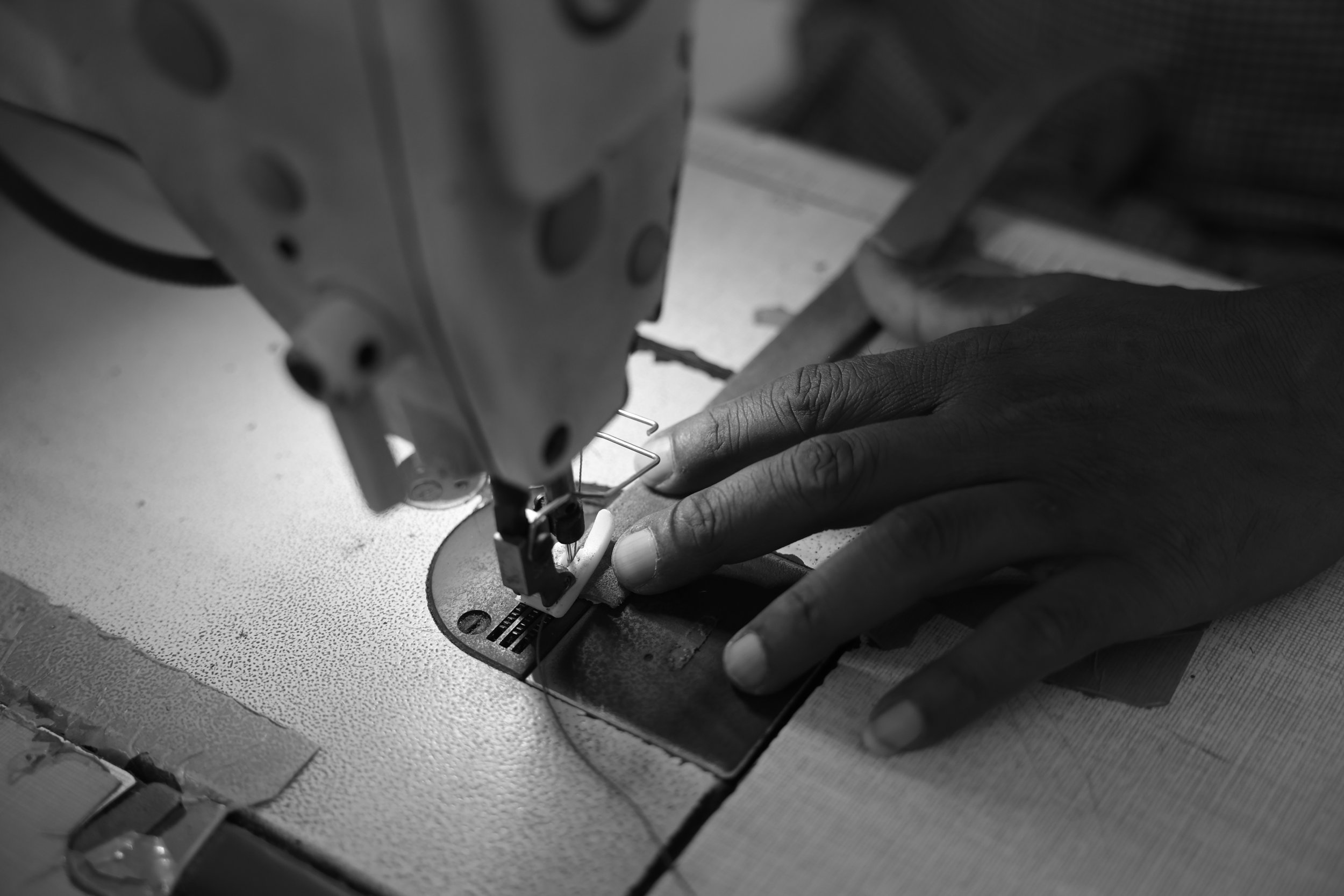 Artisan hand-crafting leather goods at Raja & Mitsu workshop